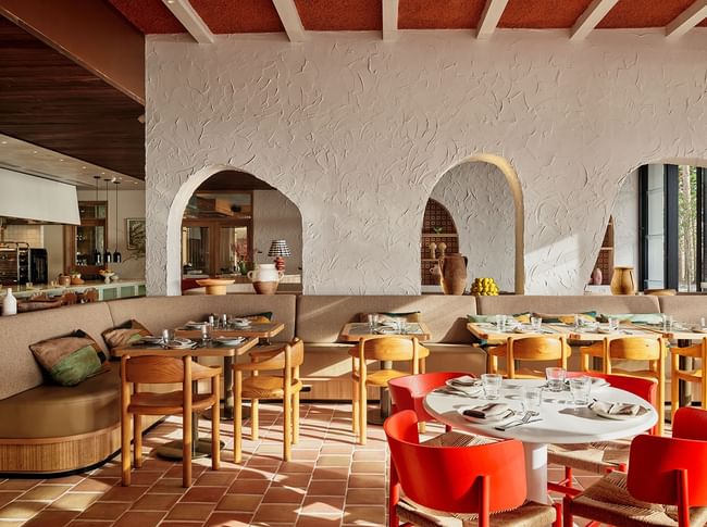 Cibaria Manly dining area at Elysium Manly featuring textured arched walls with stylish wooden tables and chairs
