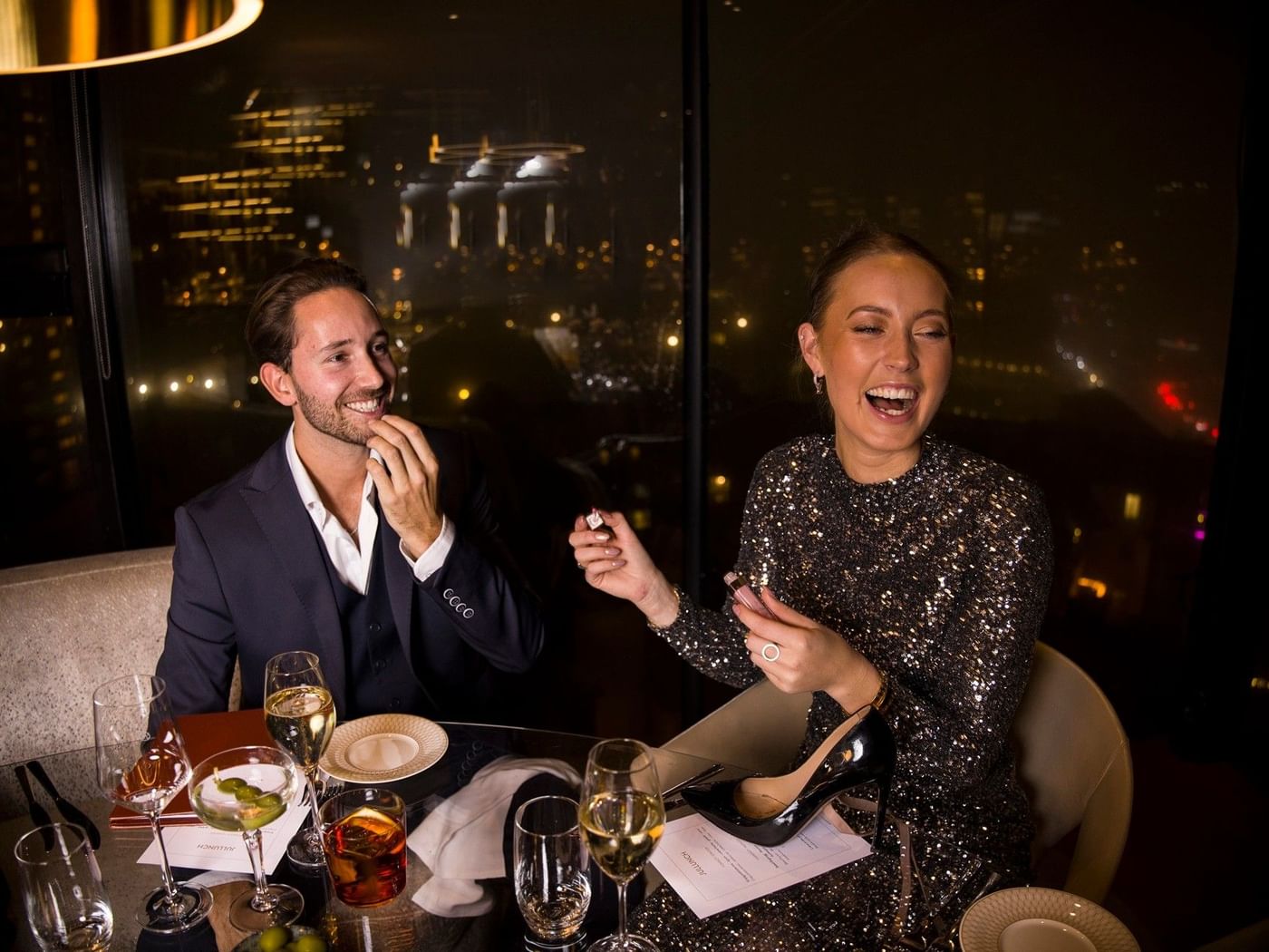 Par som njuter av champagne och en elegant nyårsmiddag med utsikt över Göteborg