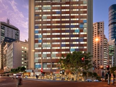 Modern multi-story building with colorful facade situated in a busy city street.