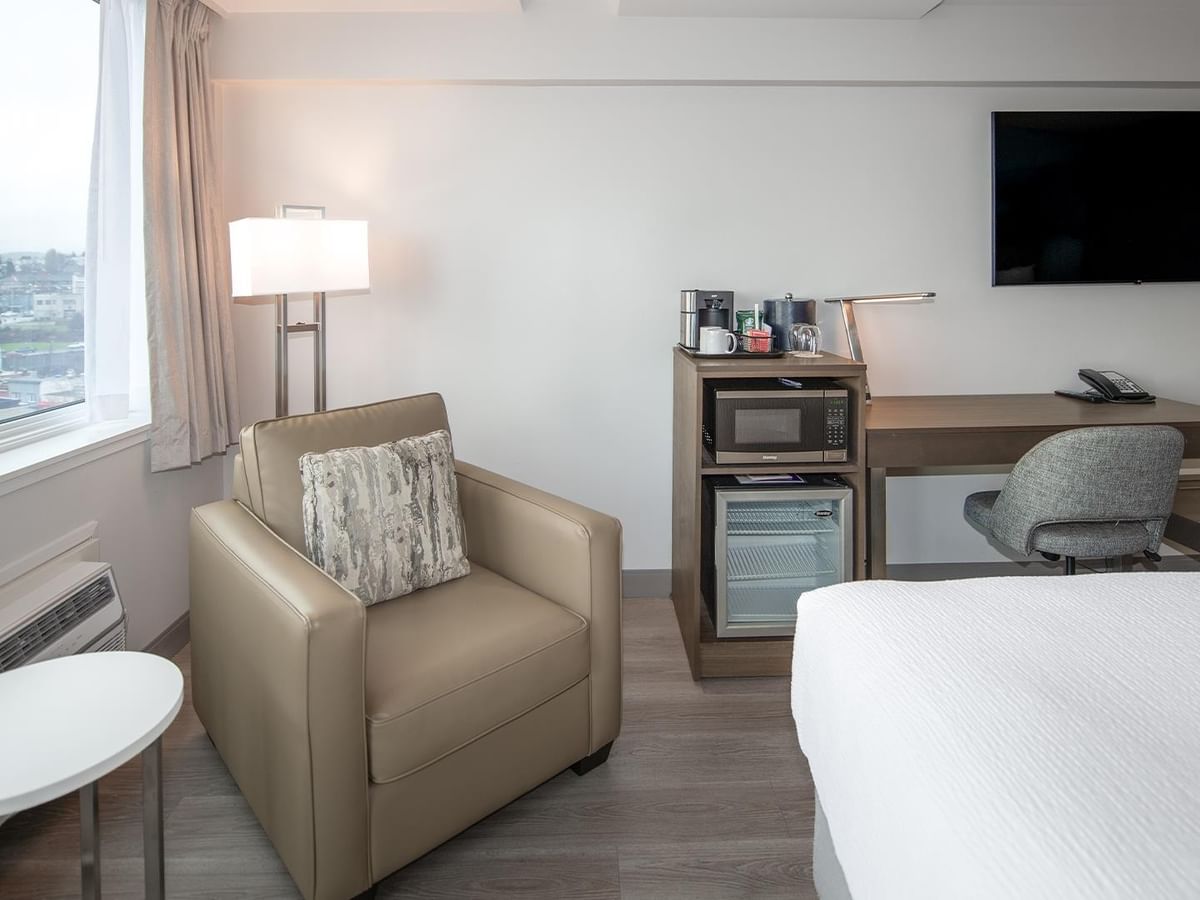 Room with two queen beds, desk, chair, microwave, fridge, and TV at Coast Bastion Hotel in Nanaimo.