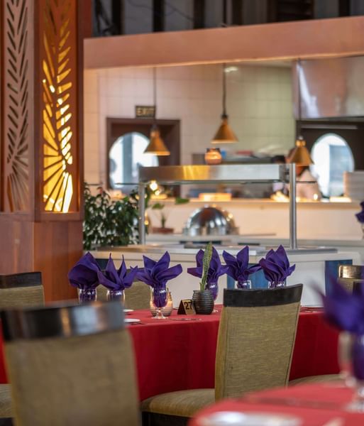 Red-clothed dining tables featuring vibrant purple napkins in KanaVata Restaurant at TokaToka Resort Nadi Fiji