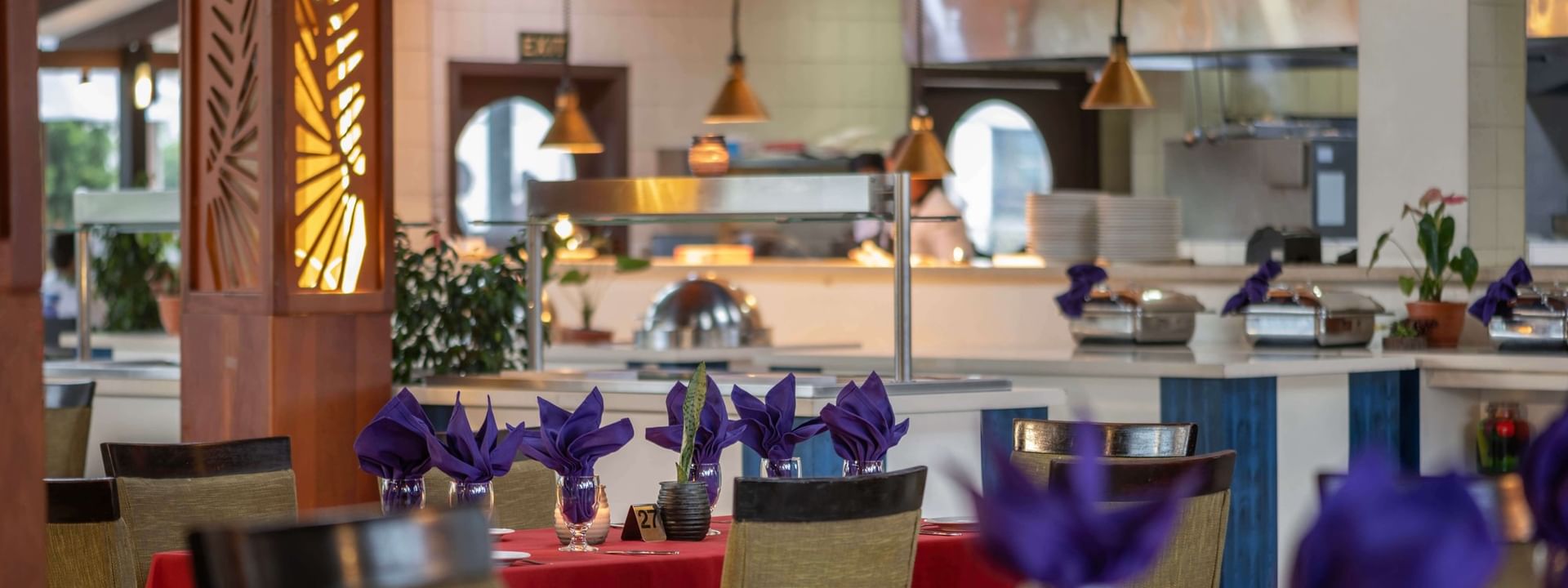 Red-clothed dining tables featuring vibrant purple napkins in KanaVata Restaurant at TokaToka Resort Nadi Fiji