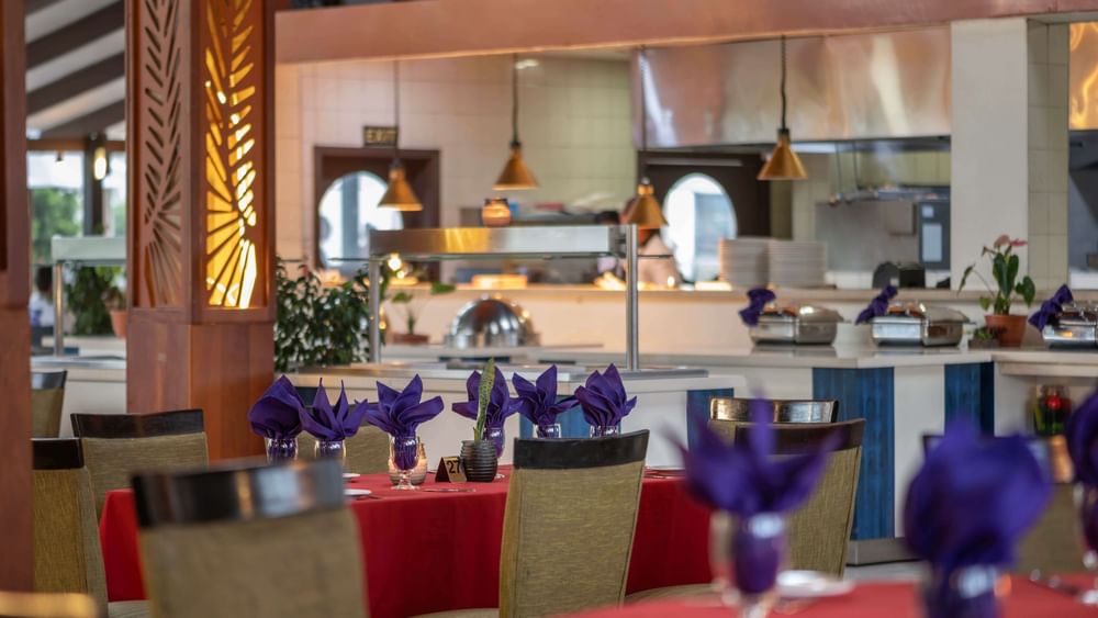 Red-clothed dining tables featuring vibrant purple napkins in KanaVata Restaurant at TokaToka Resort Nadi Fiji