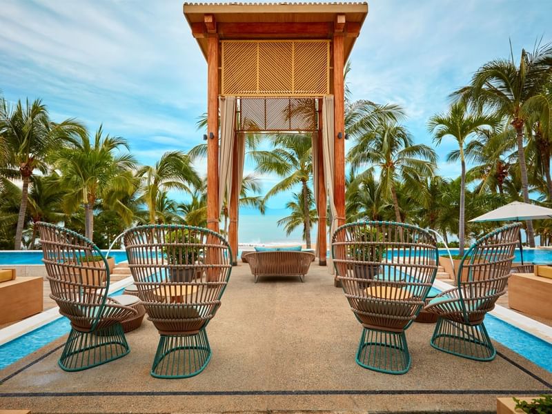 Poolside seating with wooden cabana at Fiesta Americana