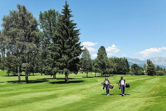 2 golfers heading toward the golf course at Schloss Hotel