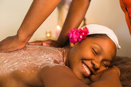 A lady getting a body Scrub in the spa at True Blue Bay Hotel