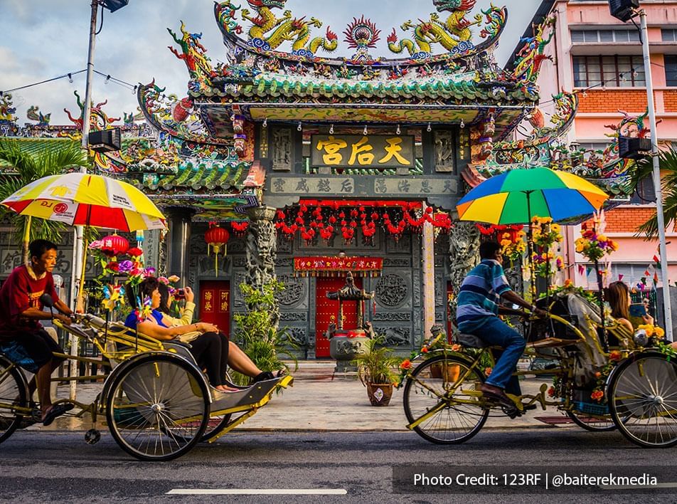 Front view of a Chinese temple in penang with local tricycles