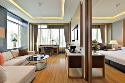 Living area with work desk, sofa & TV in Junior Suite at Eastin Hotels