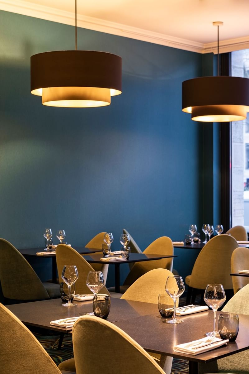 Neatly arranged dining tables in a restaurant at Oceania Hotels