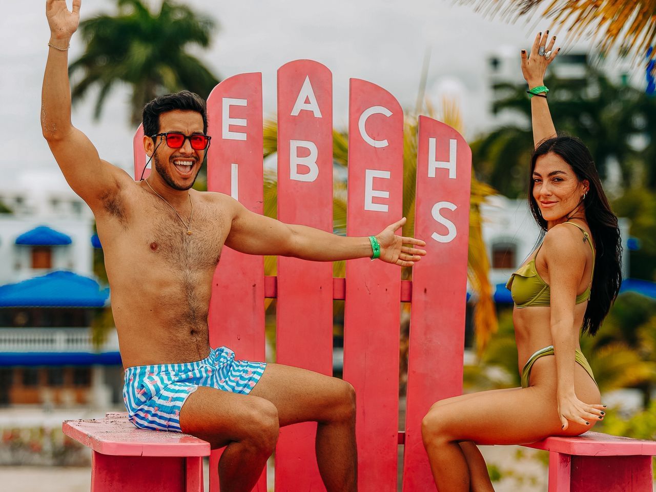Couple posing by a Beach sign at Playa Blanca Beach Resort