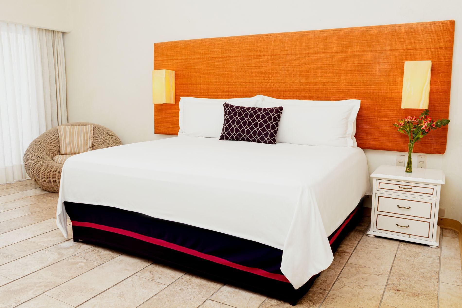 Nightstand and cozy lounge chair by the bed with cushioned headboard in King Deluxe Bed at Camino Real Zaashila Huatulco