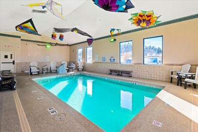 Indoor Heated Pool with loungers by the window at Boothill Inn & Suites