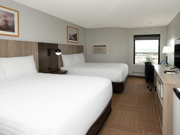 Coast Two Queens room with two queen beds, wood-style furnishings and modern amenities.