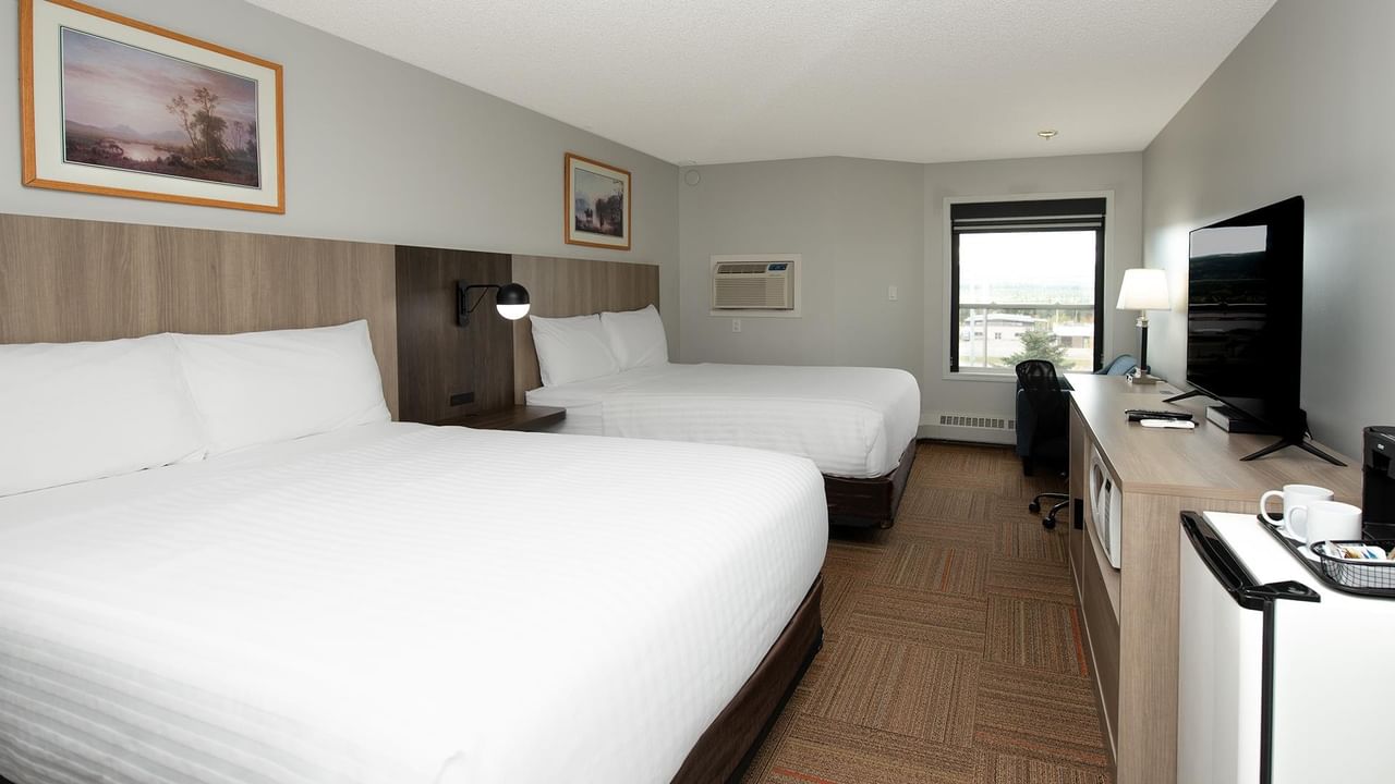 Coast Two Queens room with two queen beds, wood-style furnishings and modern amenities.