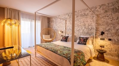 Chambre luxueuse avec lit à baldaquin et décoration tropicale pour une escapade en suite.