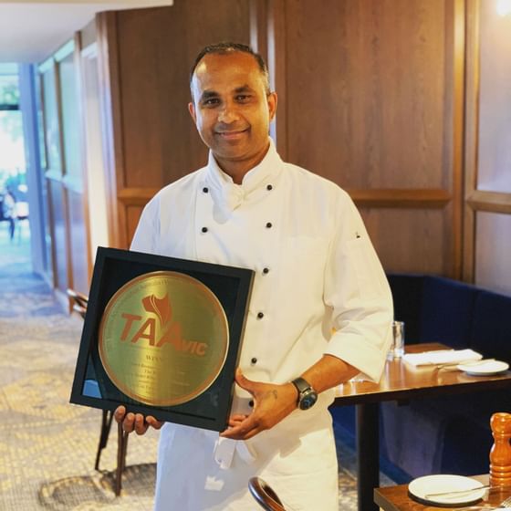 Man holding the tourism award at Amora Hotel Melbourne