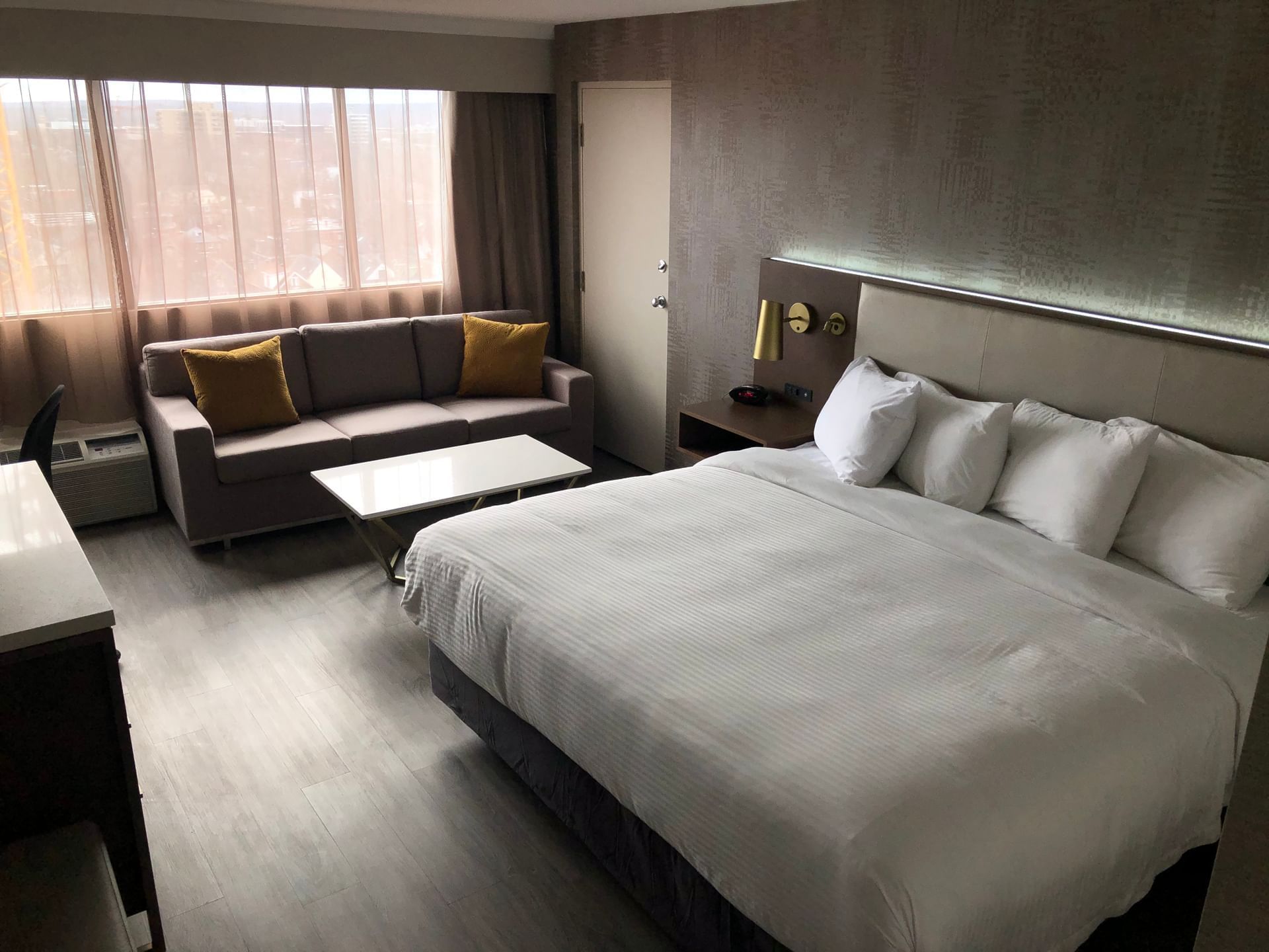 Studio room with 1 king bed, couch, and table at Atlantica Hotel Halifax.