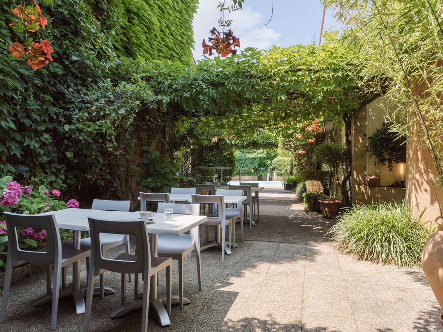 Outdoor dining area with flowers at Hotel de Bordeaux Bergerac