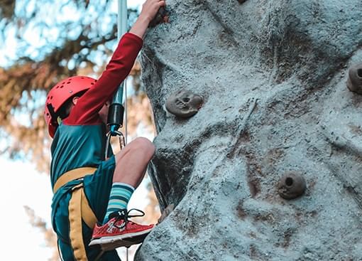 a woman climbing up a rock