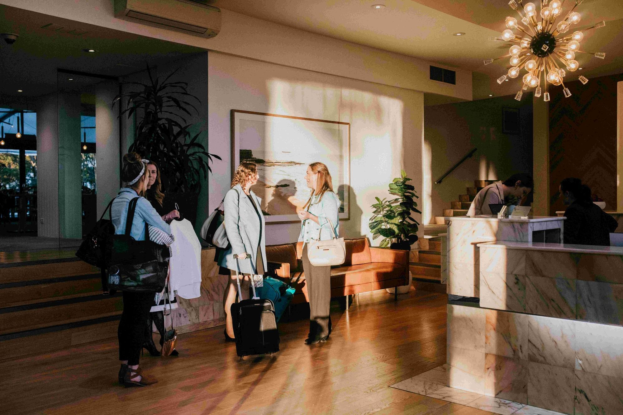 Ladies with baggage ready to check in by the lobby front desk at Mercure Charlestown