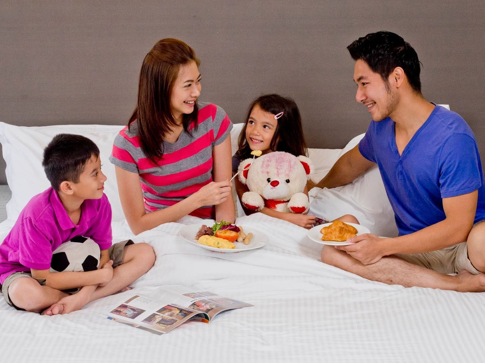 A family enjoying food and company on the bed (Room service)