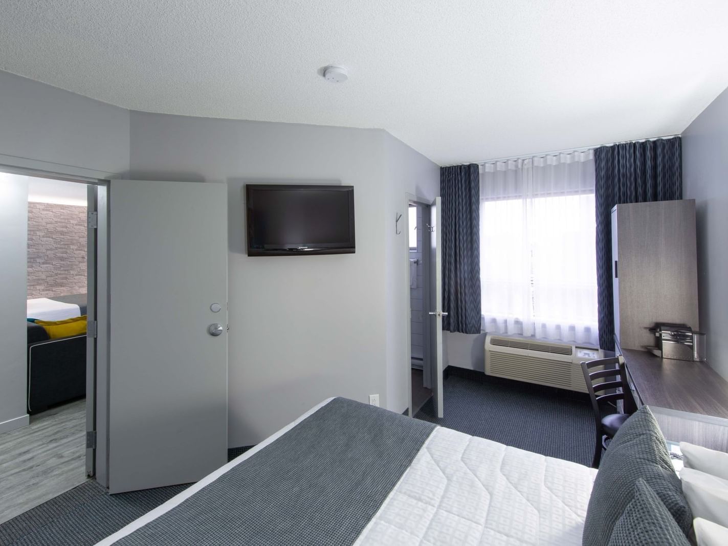 Queen bed, TV & workspace in Queen Room at Travelodge Montreal Centre