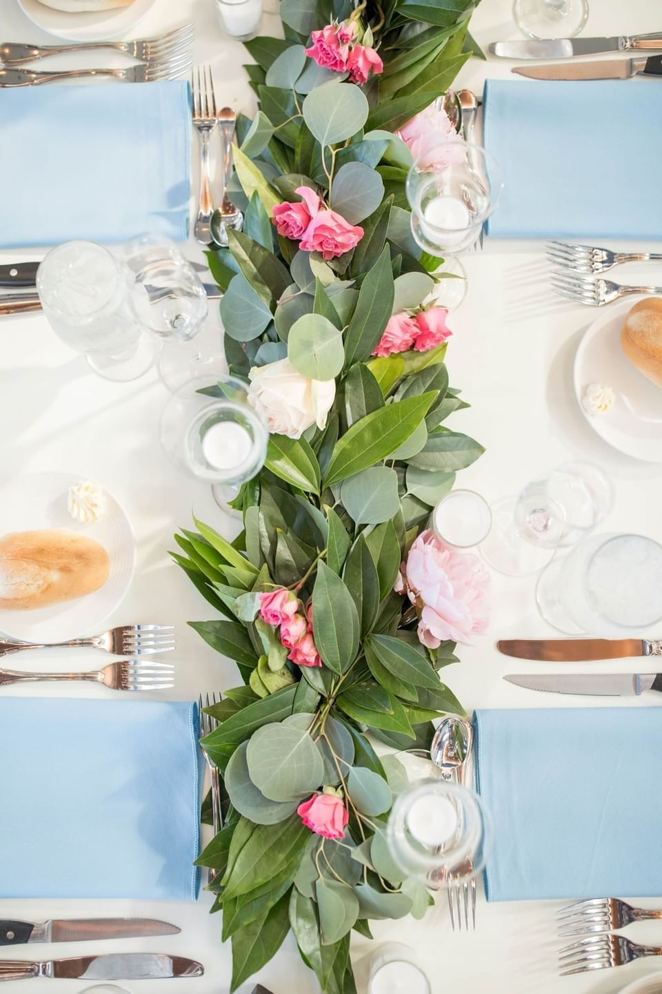 Closeup of a dining table with a flower and vine centerpiece at our Avalon wedding venue