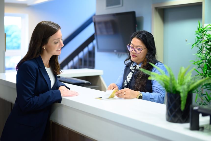 Receptionist assisting female guest at the front desk of Rodd Moncton accommodation in Moncton, New Brunswick