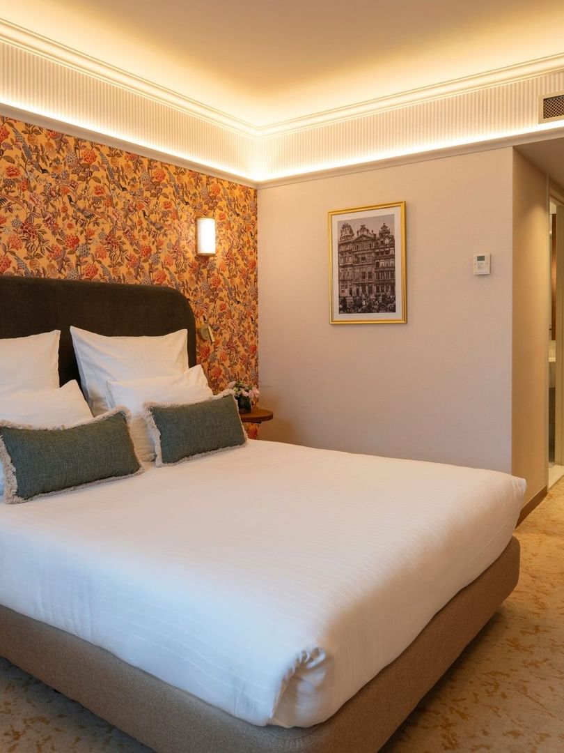 Classic Kamer met tweepersoonsbed en kleurrijk bloemmotief behang bij Warwick Brussels Grand-Place