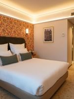 Classic Kamer met tweepersoonsbed en kleurrijk bloemmotief behang bij Warwick Brussels Grand-Place