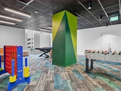 Colorful game room with foosball table, pool table, and large game board at Mayoral Drive Student Accommodation.