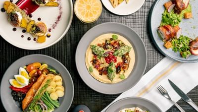 Beautifully arranged meal with  hummus, salmon salad, and a cocktail served in The Residences at Seafire