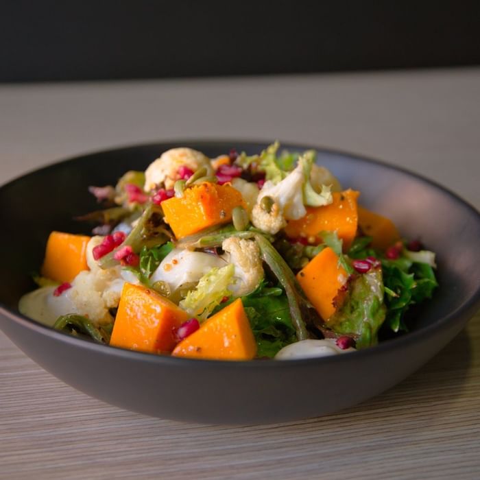 Salad with roasted pumpkin, greens, and pomegranate seeds served at Ibis Adelaide