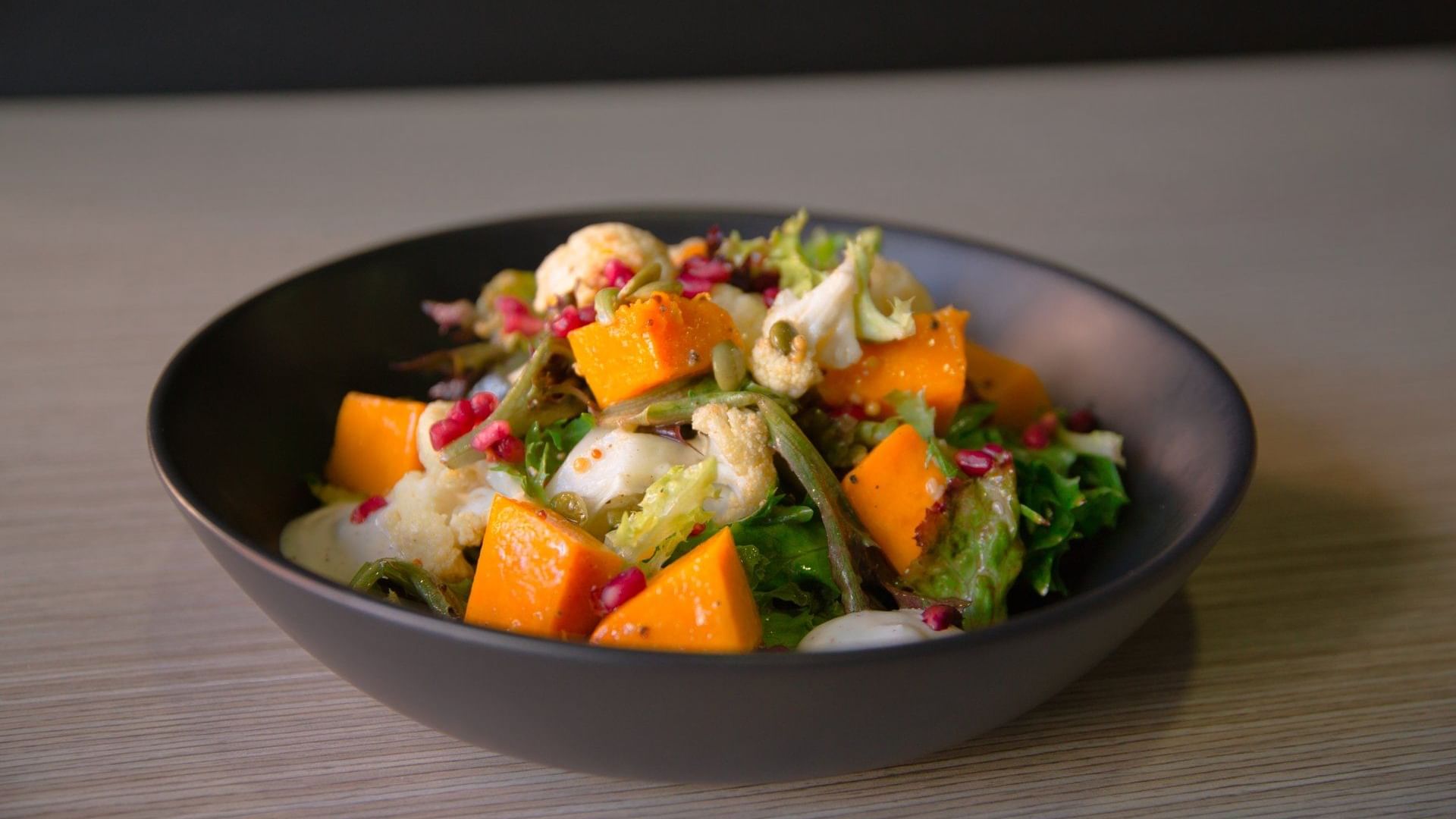 Salad with roasted pumpkin, greens, and pomegranate seeds served at Ibis Adelaide