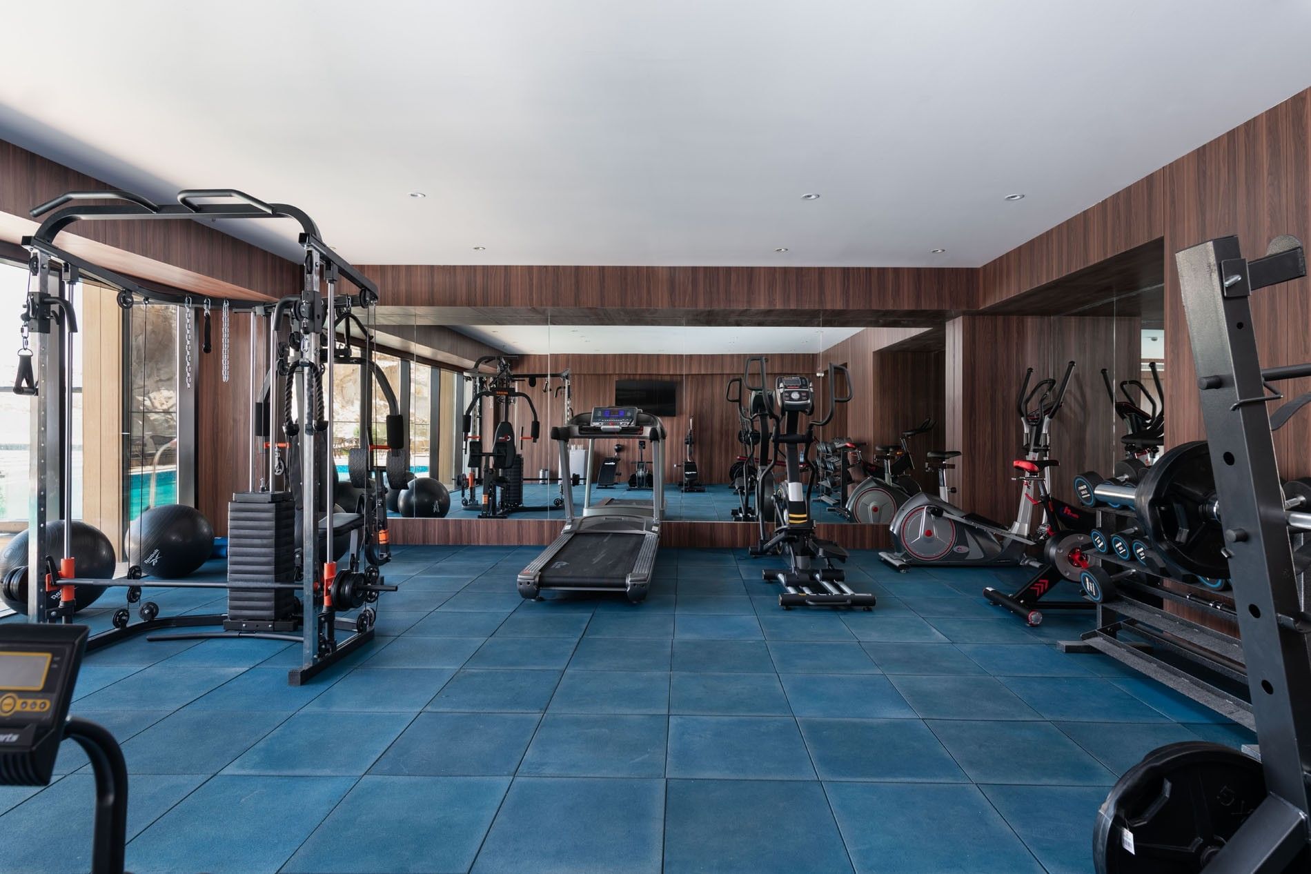 Treadmill and bikes by a mirror under recessed lights in the fitness center at Warwick Al Taif Hotel