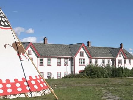 A teepee stands in front of a house at Fort Calgary exterior near Hotel Clique Calgary Airport