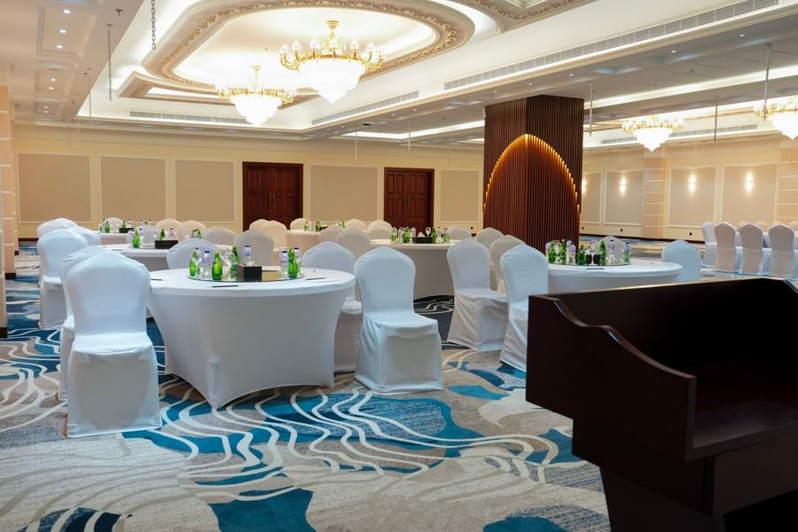 Elegantly arranged banquet hall with round tables and chairs at Warwick Hotel & Spa - Jeddah.