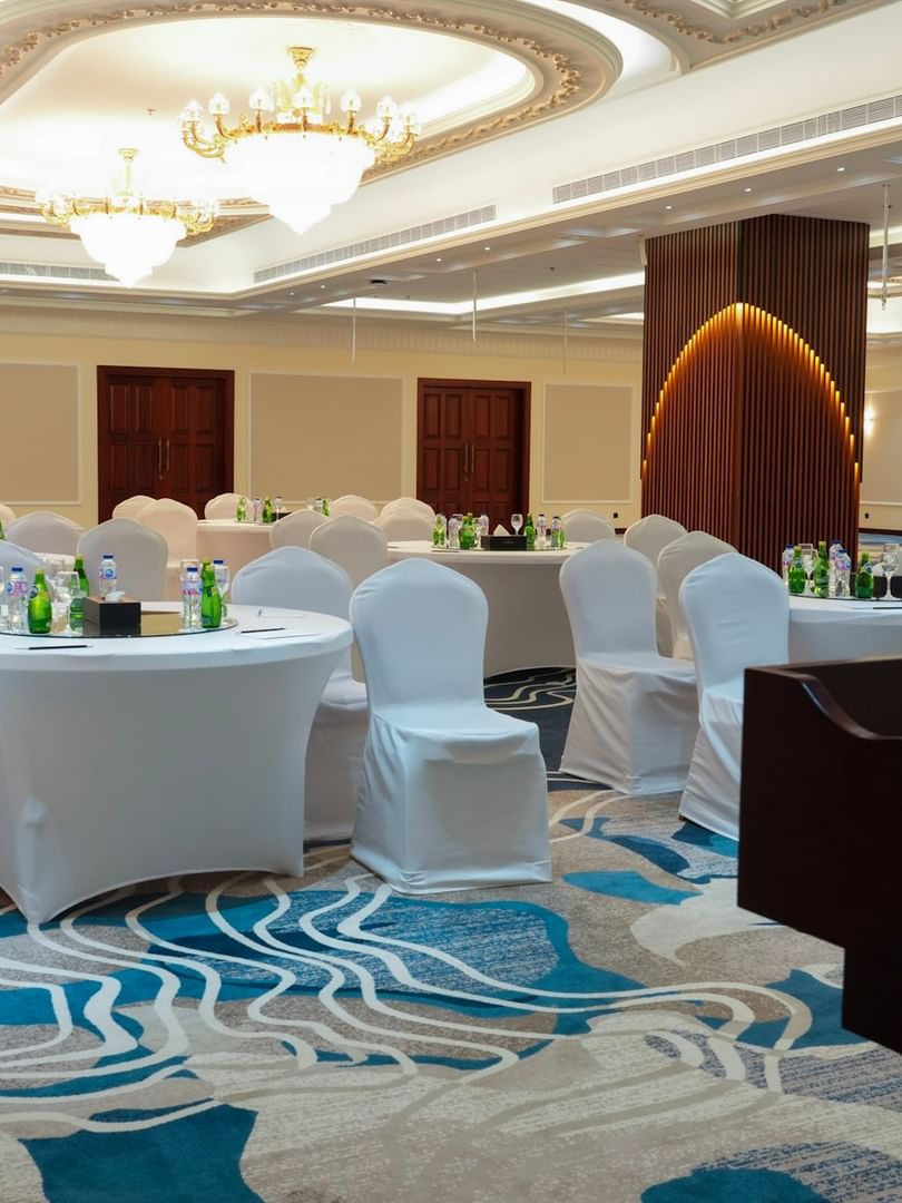 Elegant Warwick Club Lounge with round tables and white chairs at Warwick Hotel & Spa Jeddah.