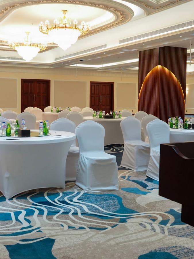 Elegant Warwick Club Lounge with round tables and white chairs at Warwick Hotel & Spa Jeddah.