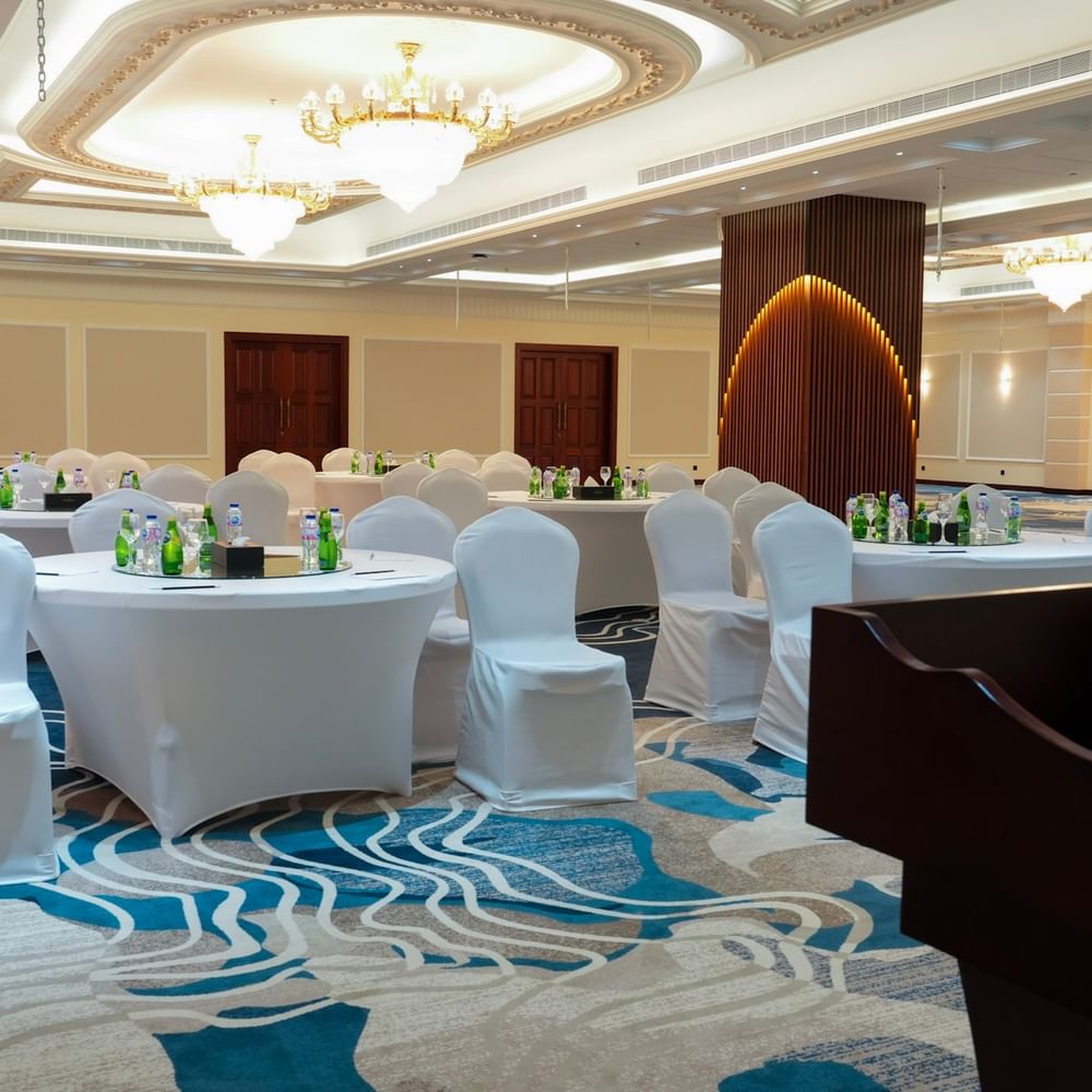 Elegant Warwick Club Lounge with round tables and white chairs at Warwick Hotel & Spa Jeddah.