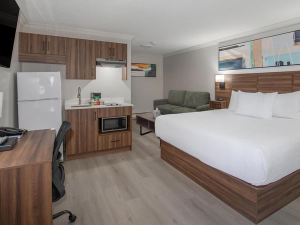 pet-friendly guest room with a king bed, sofa, kitchenette, work desk and flat-screen TV at Coast Dawson Creek Hotel