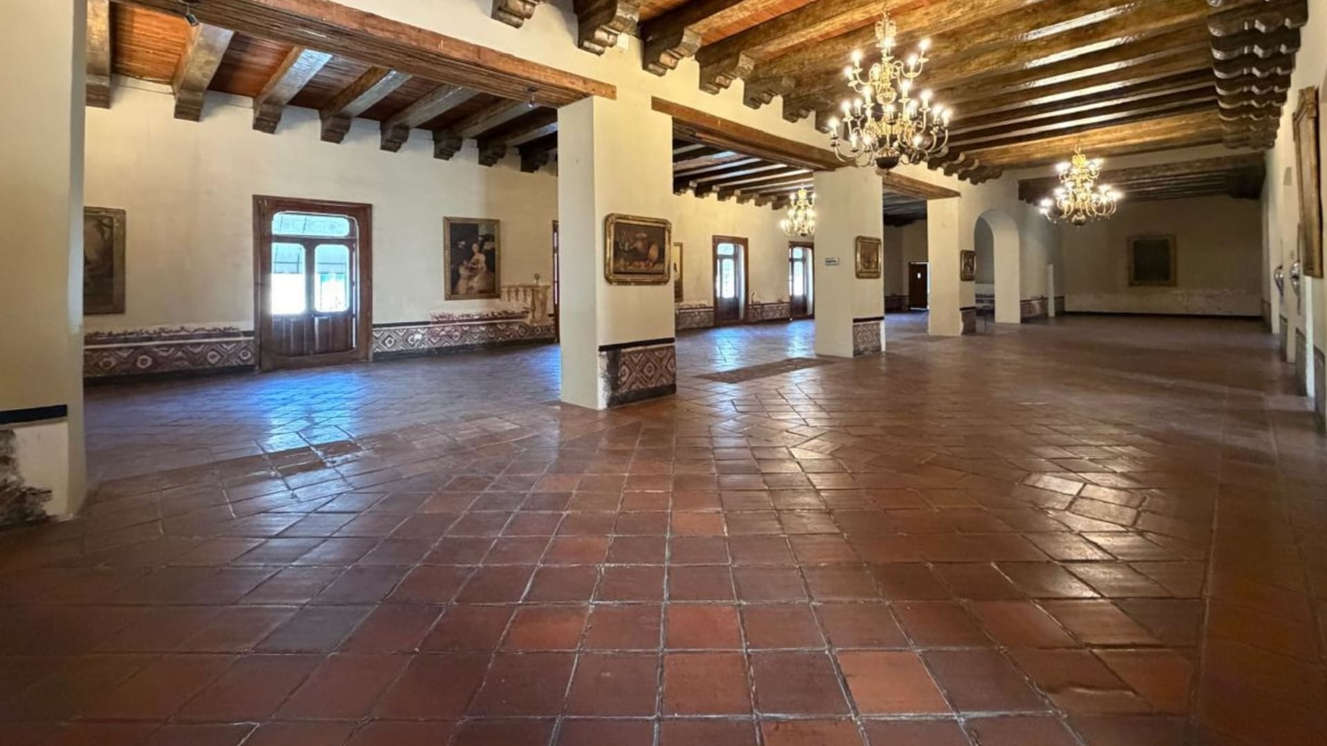 Large empty event room with wooden ceiling and chandeliers at Quinta Real Puebla in Heroica Puebla de Zaragoza.