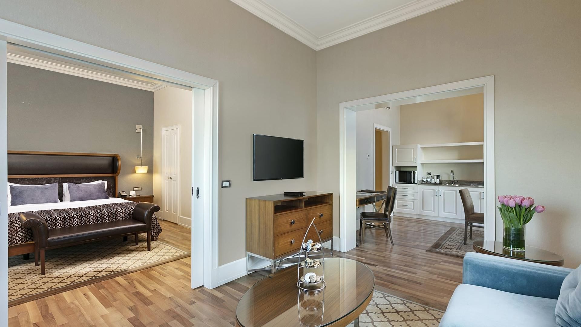 Titanic Business Kartal'daki Premier Suite'te, ahşap kaplamalı halılarla döşenmiş ferah bir oturma alanı ve konforlu koltuklar bulunmaktadır.