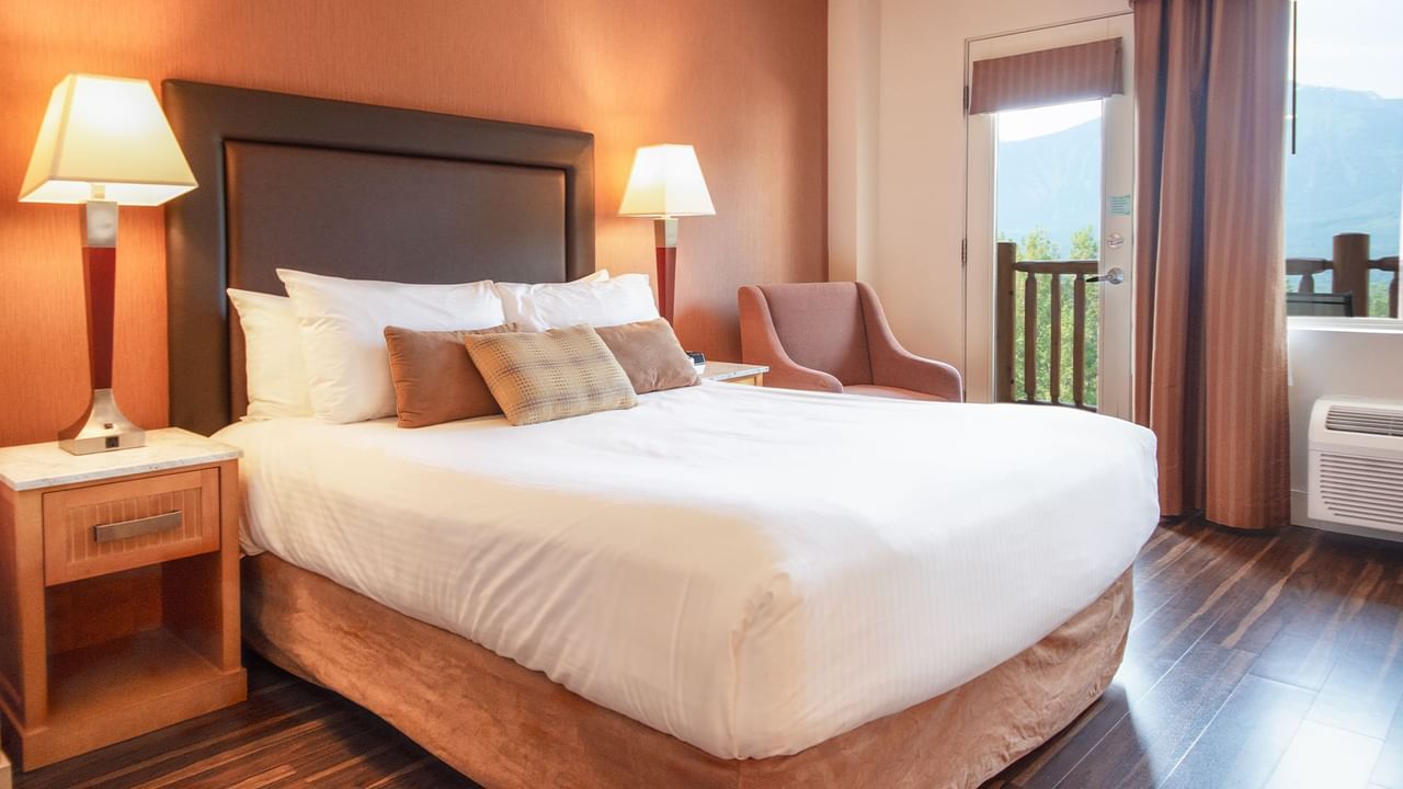 Hotel guest room with queen bed and a balcony