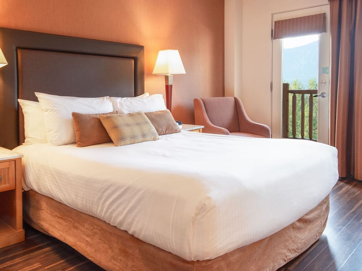 Hotel guest room with a queen bed and a balcony