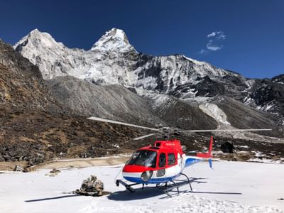 Helicopter landing on a snowy mountain near The Terraces Resort & Spa