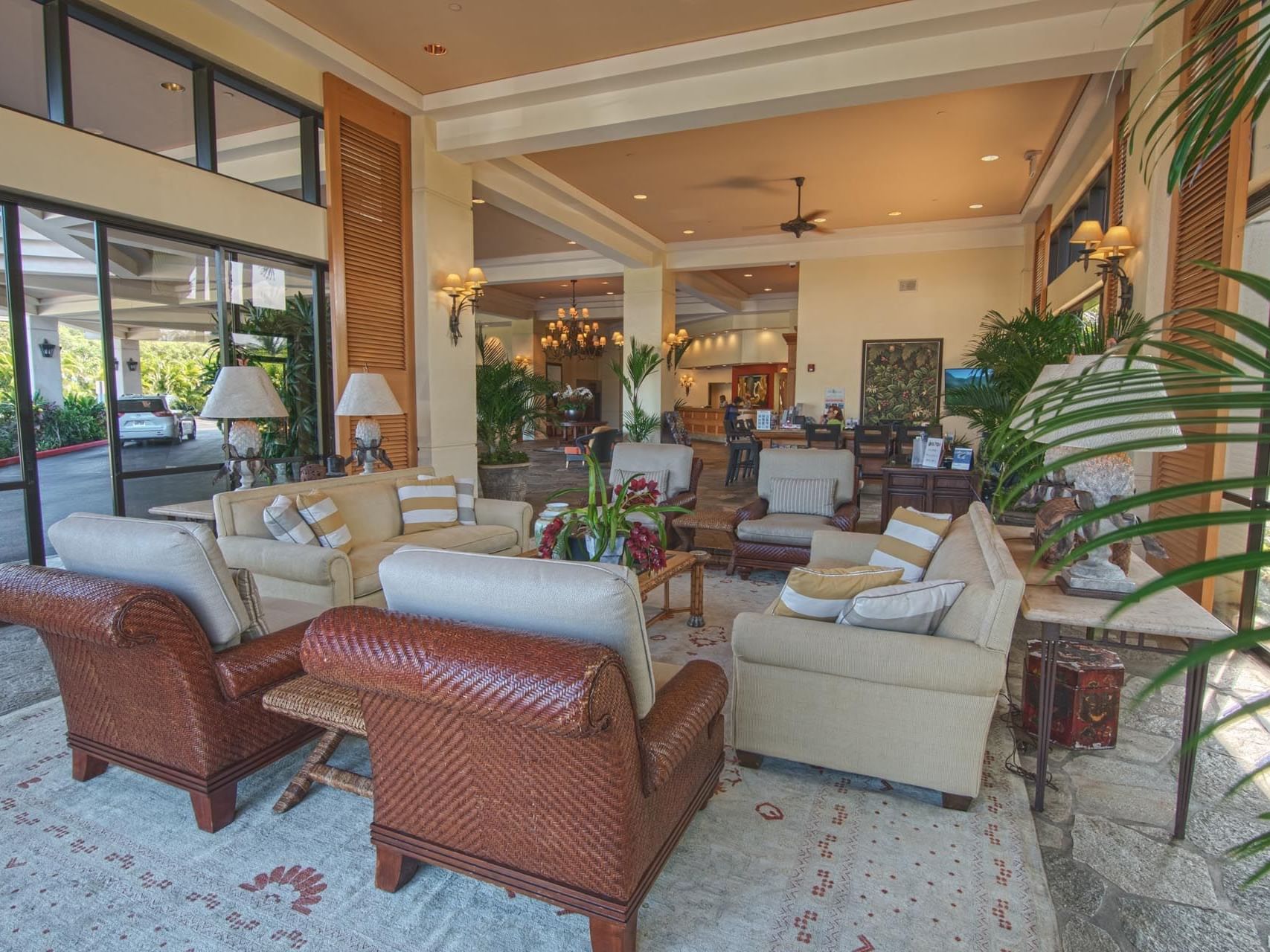 A lobby adorned with furniture & plants at Maui Coast Hotel