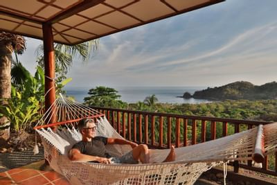 Man relaxing on a hammock in Deluxe King at Punta Islita Hotel
