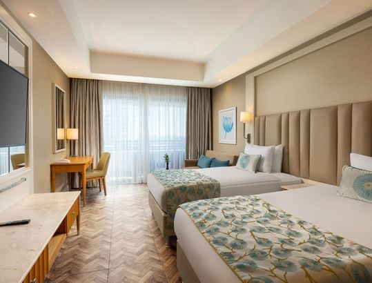 Titanic Deluxe Lara standart kara manzaralı odasında, iki yataklı ve şık detaylı lüks bir oda.