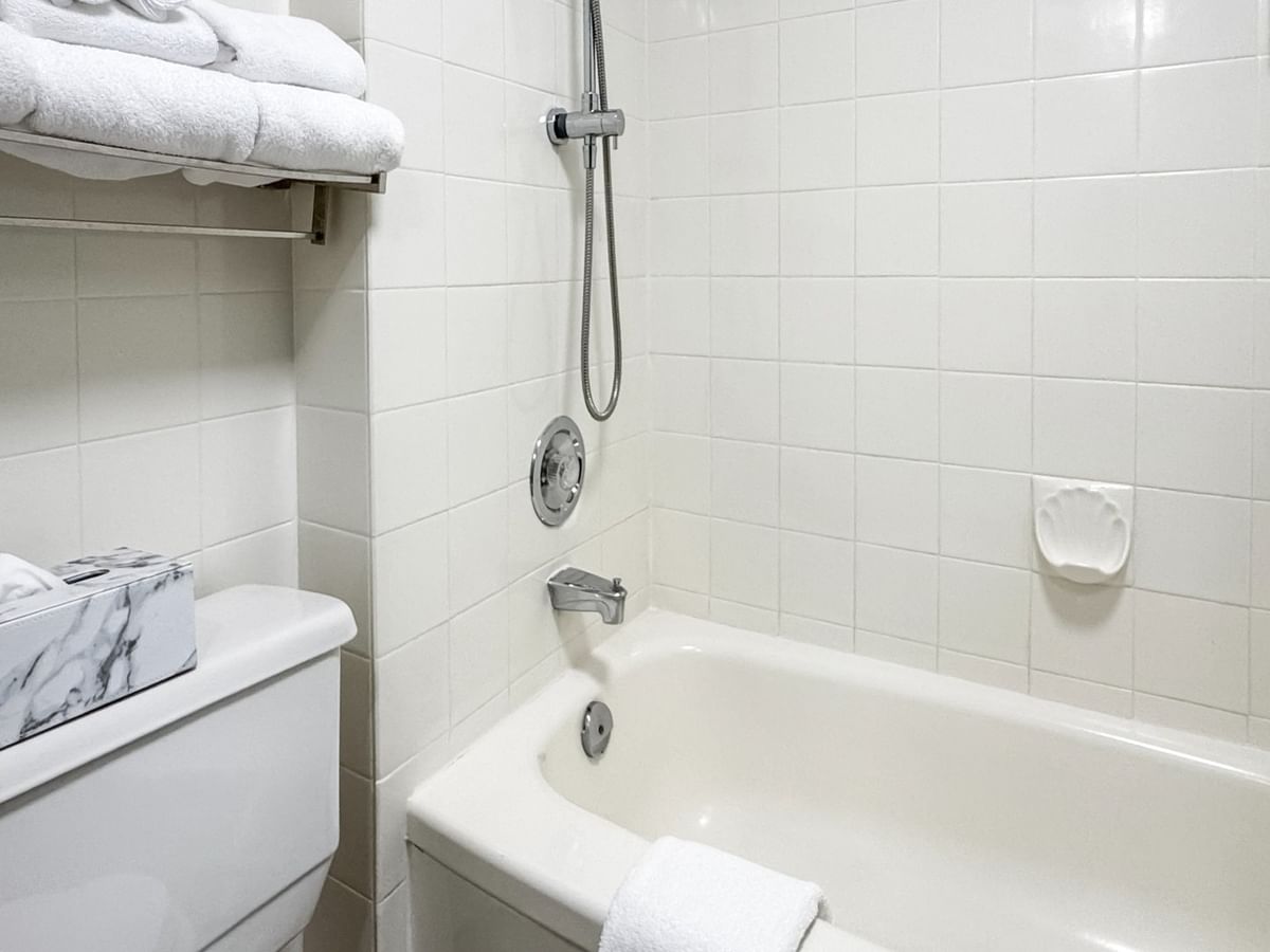 Coast King bathroom with bathtub, shower, towel rack, and toilet with tissue box at Coast Lonsdale Quay Hotel